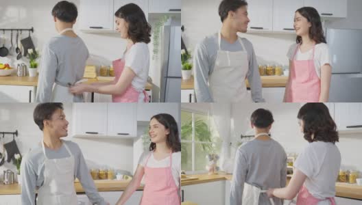 亚洲年轻新婚妻子在厨房给丈夫系围裙鞋带。有魅力的浪漫情侣穿着围裙，在家里一起度过时光，心情愉快，享受做饭、烘焙、烘焙的乐趣。高清在线视频素材下载