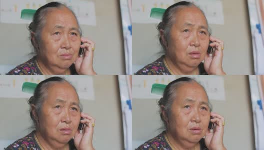 一位年长的亚洲妇女正在用手机打电话。高清在线视频素材下载