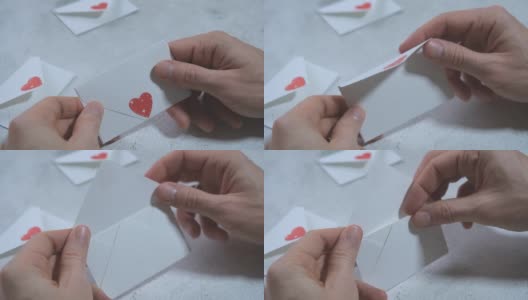 男人的手打开一个白色的信封，里面写着一颗心，抽出一张卡片，上面写着“我爱你”高清在线视频素材下载