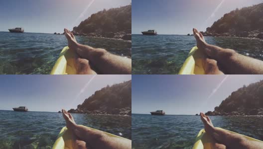 一个男人在夏天的海上的皮划艇上放松高清在线视频素材下载