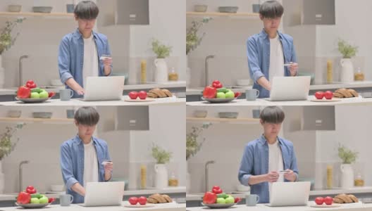 年轻的亚洲男子在厨房用笔记本电脑在线支付高清在线视频素材下载