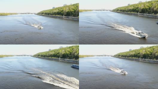 汽船沿着宽阔的城市河流疾驶。一艘白色的摩托艇漂浮在蓝色的河面上，浪花飞溅。高清在线视频素材下载