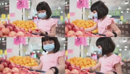 一个亚洲的中国女孩在超市买水果在周末看水蜜桃高清在线视频素材下载