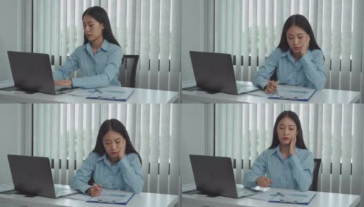 年轻的亚洲女性对工作感到厌烦，觉得在下午处理笔记本电脑上的数据很懒。高清在线视频素材下载