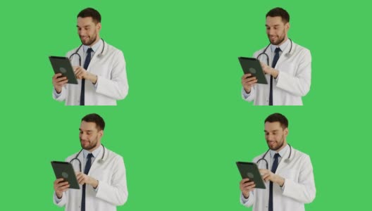 一位英俊医生在平板电脑上做滑动手势的中景。背景为绿幕。高清在线视频素材下载