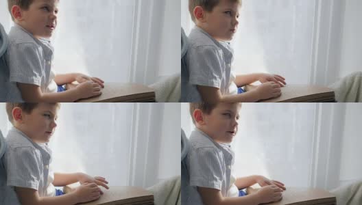手持盲文书的盲人孩子坐在窗台上读汉字字体高清在线视频素材下载