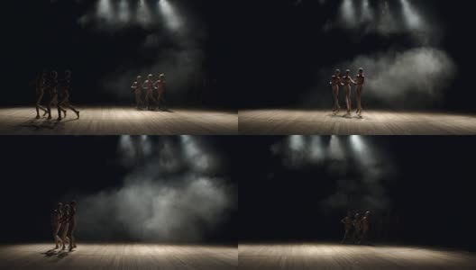一群孩子在黑暗中在舞台上跳芭蕾舞。高清在线视频素材下载