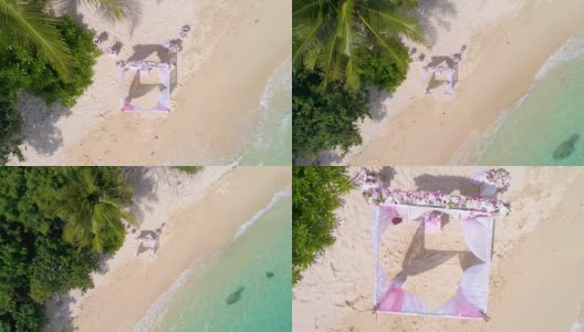 航拍:棕榈滩上美丽的鲜花婚礼拱门。高清在线视频素材下载