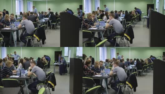 大学的现代教育过程。听众中有很多学生坐在桌子旁，用笔记本电脑学习信息。大型宽敞的类高清在线视频素材下载