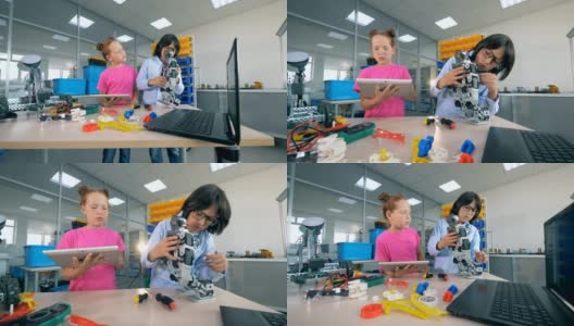 两个孩子在学校实验室里建造一个塑料机器人。技术教育的概念。高清在线视频素材下载