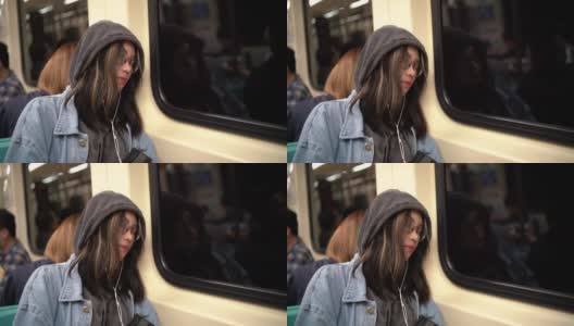 一个年轻的亚洲女人睡在地铁里高清在线视频素材下载
