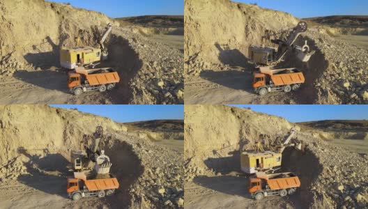 露天矿山建筑用砂石材料用挖掘机装石料自卸卡车鸟瞰图。重型设备在采矿和生产中具有实用的矿物概念高清在线视频素材下载