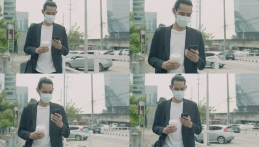 在新型冠状病毒感染症(covid-19病毒)流行期间，英俊的亚洲商人戴着医用口罩，在城市街道上行走，使用智能手机。高清在线视频素材下载