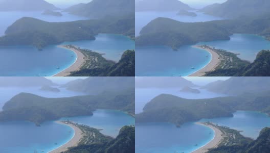 在土耳其的蓝色泻湖Oludeniz上空滑翔，飞过大海和山脉高清在线视频素材下载