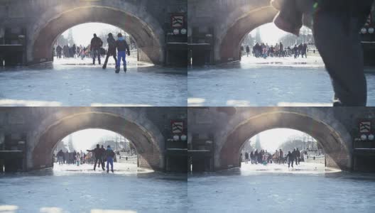 在冰冷的阿姆斯特丹运河桥下滑冰高清在线视频素材下载