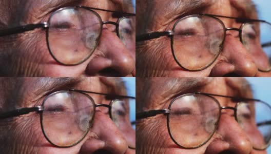 一位戴着眼镜的老人的特写脸，在阳光下眺望远方。眼光和老年人的观念高清在线视频素材下载