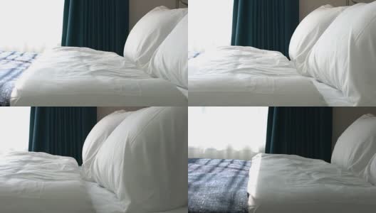 在美丽的卧室里，用干净的白色枕头和床单装饰床。高清在线视频素材下载