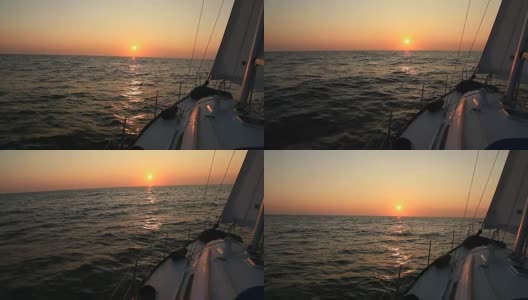 从一艘帆船的甲板上看，索具和前帆的剪影映衬着灿烂的日落或日出的天空高清在线视频素材下载