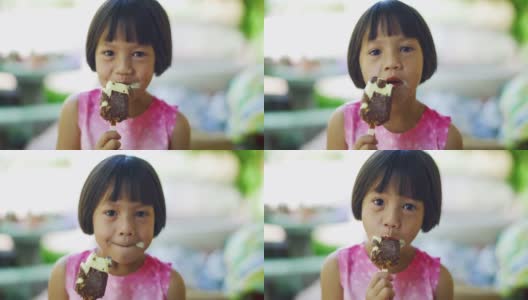 可爱的女孩正带着积极的情绪，放松，享受吃巧克力冰淇淋零食。高清在线视频素材下载
