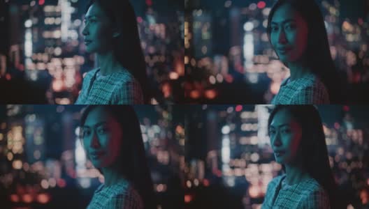 深夜霓虹灯下美丽的亚洲女性肖像站在城市街道。真实的成年自信女人在镜头前摆姿势，在市中心商业街的夜晚微笑。高清在线视频素材下载