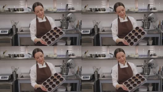 一位女糕点师在厨房里拿着制作果仁巧克力的表格。高清在线视频素材下载