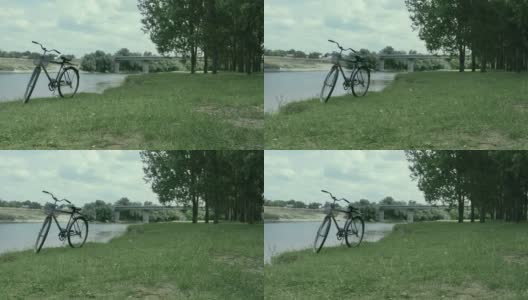 自行车站在离桥不远的河岸上高清在线视频素材下载