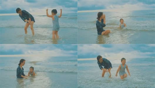 亚洲年轻的母亲和小女儿在海滩上玩得很开心高清在线视频素材下载