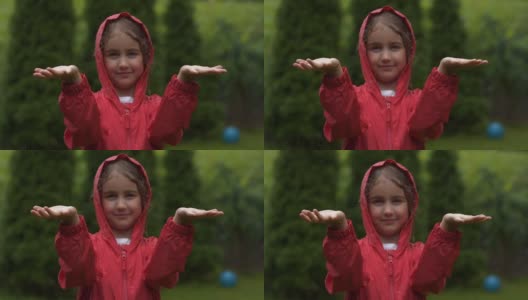 快乐的小女孩在雨中微笑。孩子爱自然，快乐自由。孩子玩雨滴。下雨的夏天，孩子们在户外玩耍。秋雨中穿红雨衣的女孩。高清在线视频素材下载