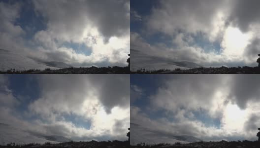 冬天的风景。蓝色的天空上飘动着毛茸茸的白云。山上覆盖着雪高清在线视频素材下载