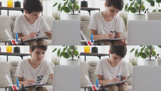男孩在家里用笔记本电脑和写书高清在线视频素材下载