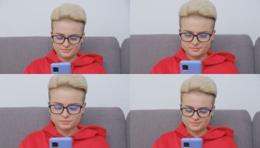 漂亮的假小子女人戴着眼镜用手机。视频肖像有吸引力的白人女性染短头发浏览互联网和社交媒体上的现代智能手机gadget高清在线视频素材下载