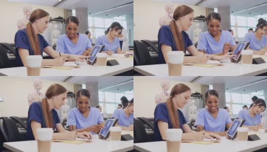 两名医学院女学生用数码平板电脑看头骨x光片高清在线视频素材下载