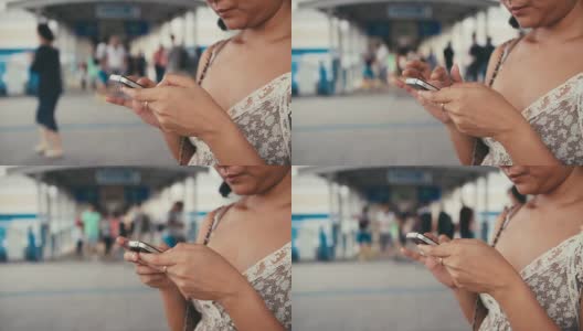 一名亚洲女性在城市场景中通过智能手机阅读信息高清在线视频素材下载