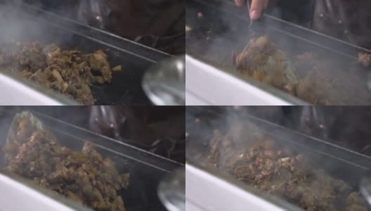 成堆的肉陈列在墨西哥街头小贩的烧烤架上，taquero sautéing慢镜头中的肉。高清在线视频素材下载