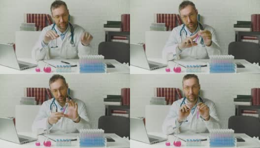 医生在网上视频通话中谈论最新的疫苗。他把疫苗样本放到相机里，并在谈论这些发现时积极地做手势高清在线视频素材下载