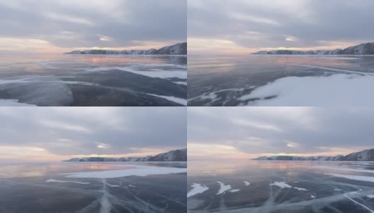 北方景观冻结湖无人机飞行下来与美丽的反射在日落4K。令人惊叹的冬季贝加尔湖和红色的日出。观看无人机在北方霜冻湖上的飞行。自然反射日落高清在线视频素材下载