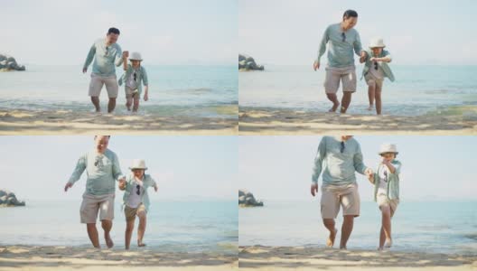 亚洲父亲和儿子跑步和玩耍，在沙滩上一起享受美好时光，慢镜头高清在线视频素材下载