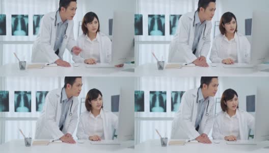 两名医生在医务室的电脑显示器上分析讨论高清在线视频素材下载