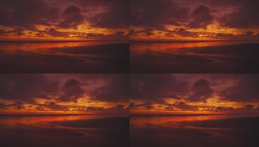 美丽的日落cinemagraph /无缝视频循环在曼纽尔安东尼奥国家公园宽广和遥远的太平洋沙滩，哥斯达黎加。云朵把整个天空和海浪都染成了红色。一只小乌龟正向水里游去。高清在线视频素材下载