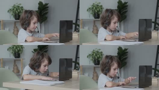 认真专注的男孩通过视频聊天笔记本电脑在线学习。孩子学习电脑高清在线视频素材下载