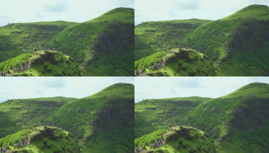 印度古吉拉特邦萨普特拉的总督山的广角镜头。萨哈德里山脉的绿色丘陵在季风季节。人们在假期期间在萨普塔拉的绿色山丘上徒步旅行。高清在线视频素材下载