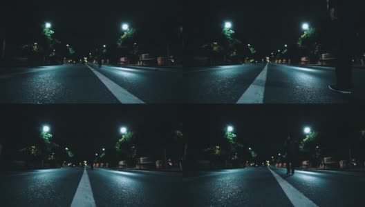 从后面可以看到一个男人在夜晚独自走在废弃的道路中间高清在线视频素材下载
