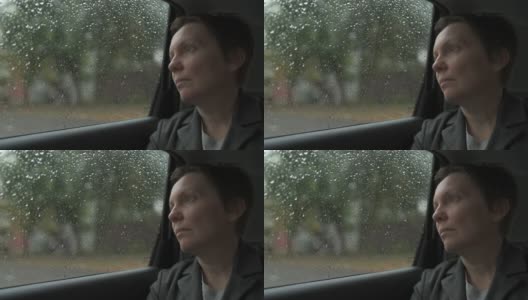 一个忧心忡忡的女商人，在雨中等在车里，望着窗外高清在线视频素材下载