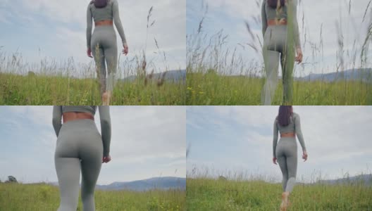 健康的女人走在草地上赤脚的背影高清在线视频素材下载