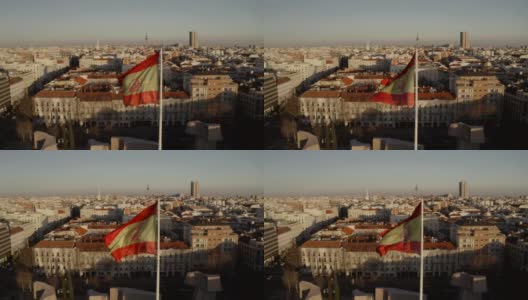 马德里,西班牙。日落时的城市全景、建筑物、街道和屋顶的房屋，从顶部观看。在画框的中央，西班牙国旗迎风飘扬高清在线视频素材下载