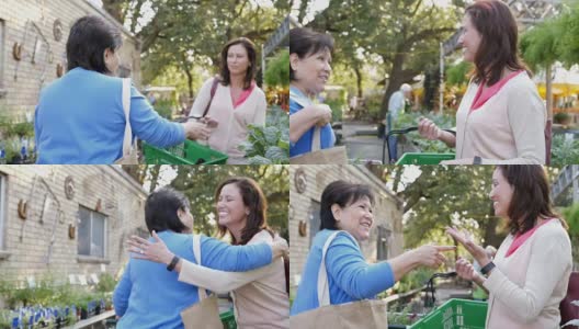 Mid-adult Caucasian women and mature Hispanic woman exchange a hug in a local farmer's market高清在线视频素材下载