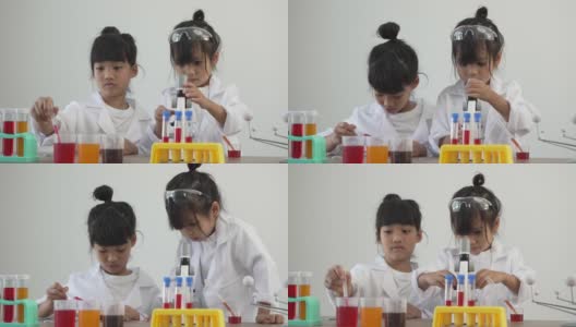 亚洲儿童穿着实验服，在家庭学校实验室里用显微镜做科学实验高清在线视频素材下载
