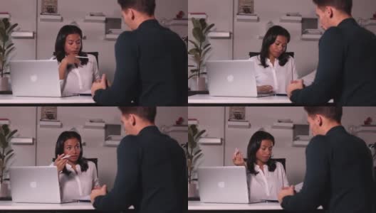 在现代办公室的桌子上，女人和男人在面试中交谈高清在线视频素材下载