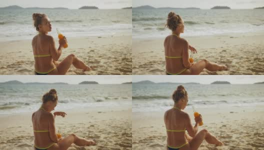 一个穿着泳装的孤独女人在沙滩上喝酒。离别的爱情，和丈夫离婚，糟糕的关系。酒类消费定义概念高清在线视频素材下载