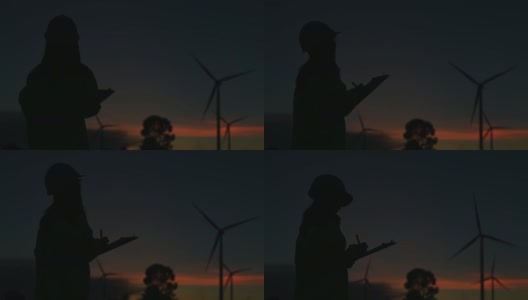 在风力发电厂工作的女工程师的剪影高清在线视频素材下载